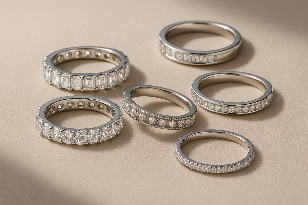 a selection of diamond eternity rings of different styles sat on a neutral surface